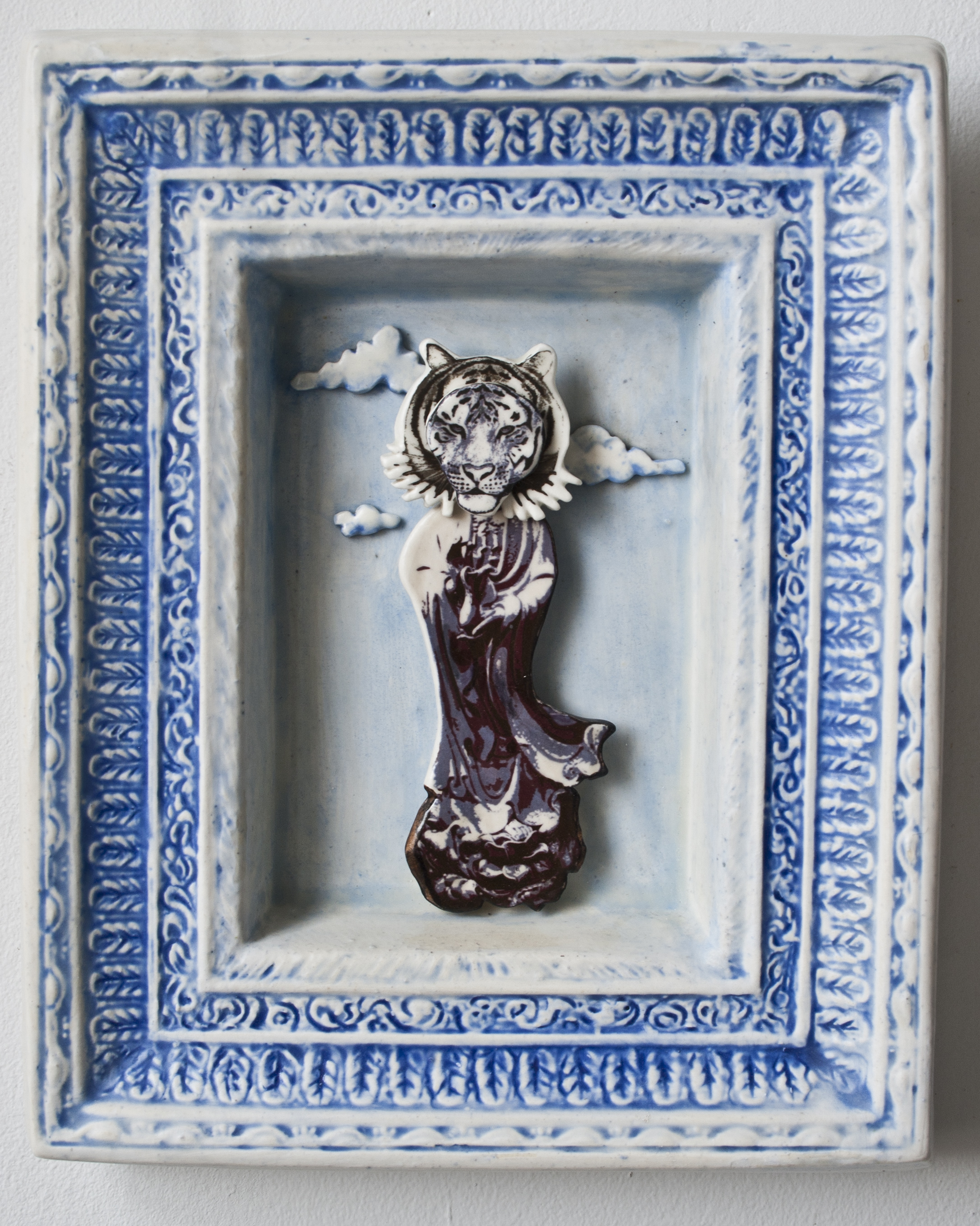 tiger head on kwan yin image in front of clouds